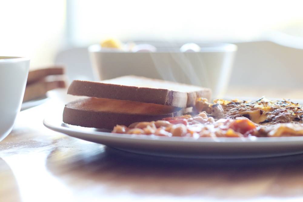 English Breakfast wird im Café Miller mit vegetarischen Seitanwürstchen serviert / ©Unsplash/Debora Cardenas