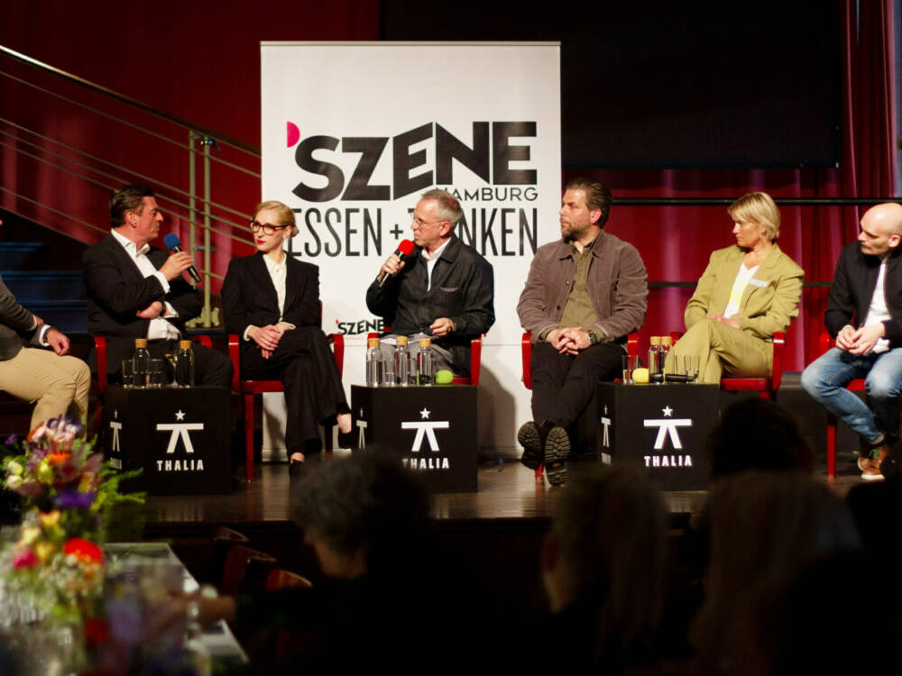 Moderator Markus Tirok (Mitte) diskutiert mit Björn Juhnke (Haco/von rechts), Folke Kaempfe (Alte Rader Schule), Hannes Schröder (u.a. Küchen- freunde), Sophie Lehmann (100/200 Kitchen), Ingo C. Peters (Vier Jahreszeiten) und Michael Finck (Frischeparadies) im Thalia in der Gaußstraße / ©Johanna Zobel