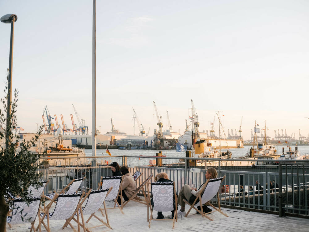 Vom Sonnendeck St. Pauli blickt man auf Wasser, Kräne und untergehende Sonne / ©Lea Harms