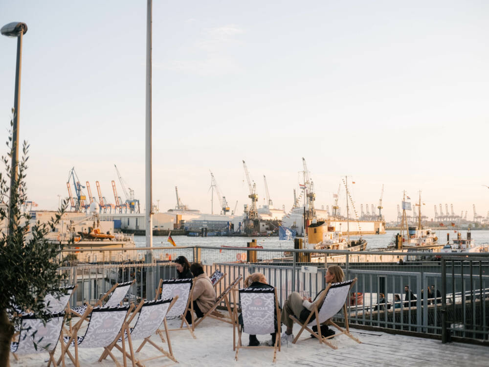 Vom Sonnendeck St. Pauli blickt man auf Wasser, Kräne und untergehende Sonne / ©Lea Harms