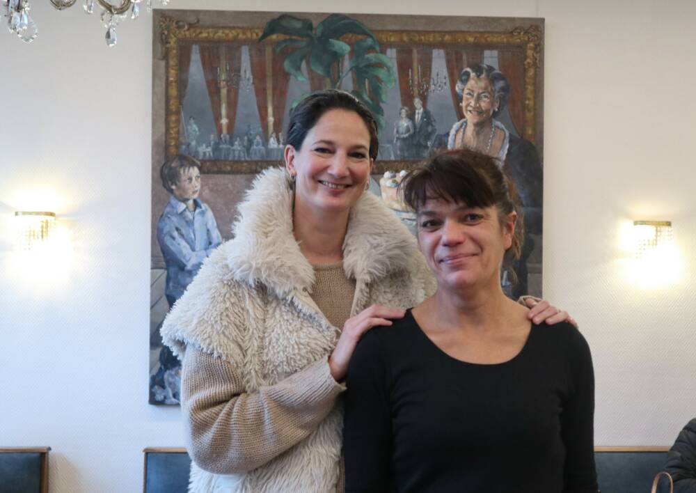 Alexa Grau (l.), Tochter von Inhaberin Angelika Besch, mit der langjährigen Mitarbeiterin Vera vor dem Familienporträt (r.). /©Alina Fedorova