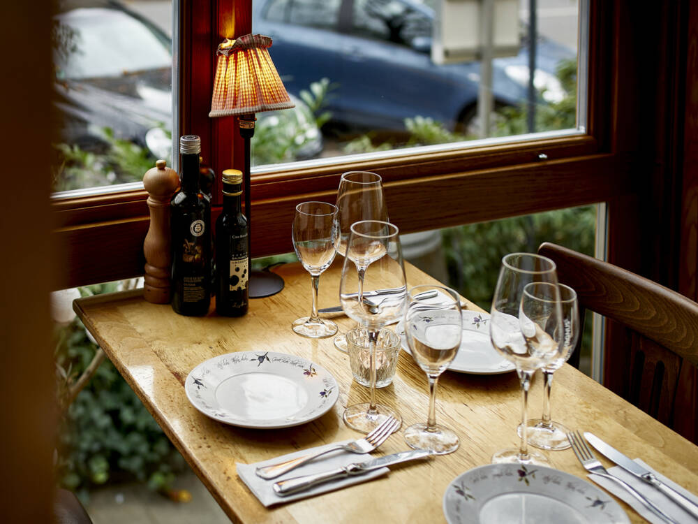 Von den Plätzen an den bodentiefen Fenstern hat man einen guten Blick auf den gemütlichen Außenbereich des Restaurants / ©Marc Sill
