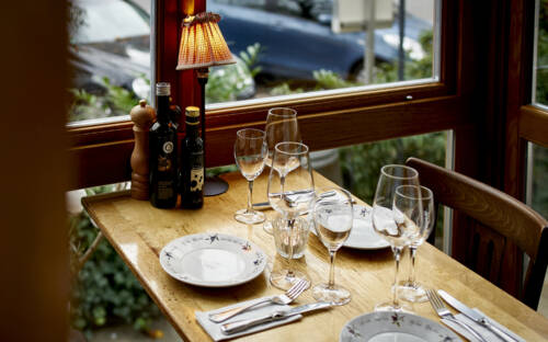 Von den Plätzen an den bodentiefen Fenstern hat man einen guten Blick auf den gemütlichen Außenbereich des Restaurants / ©Marc Sill