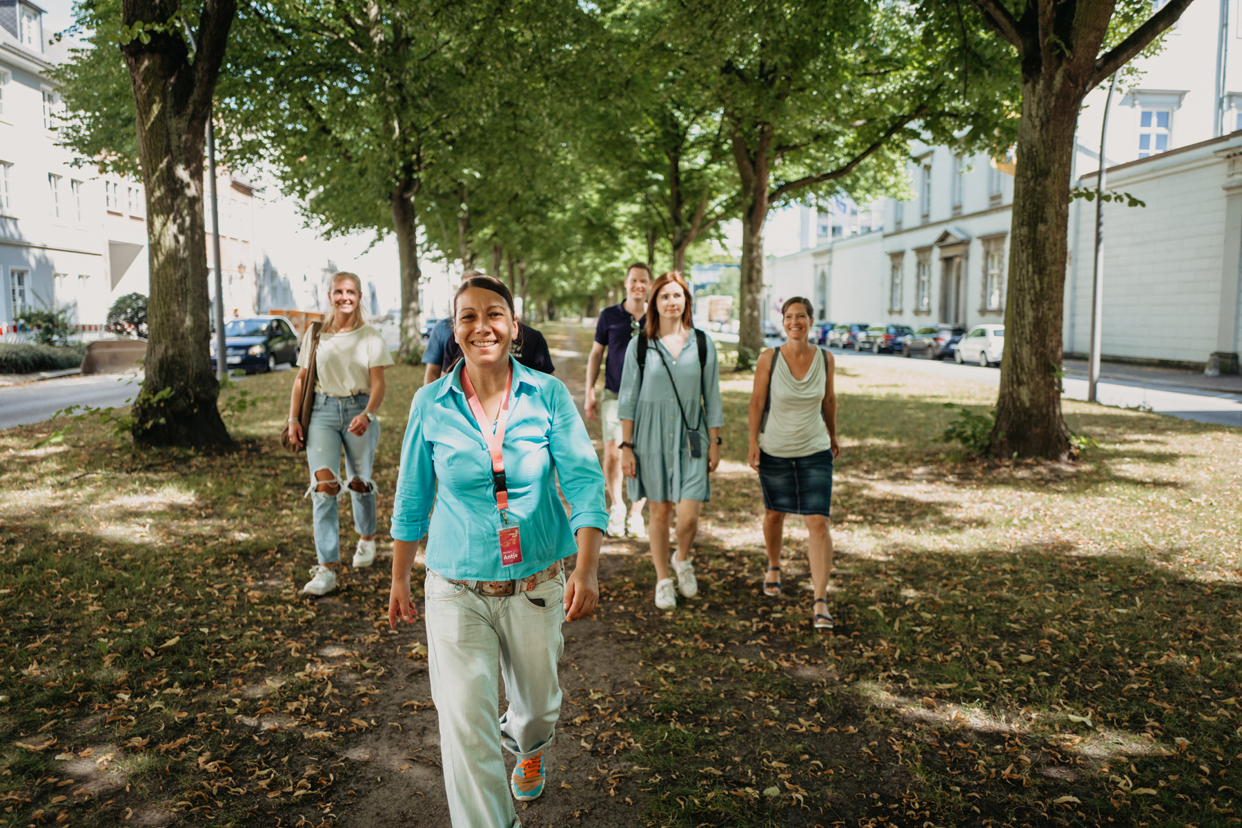 Eine Gruppe spaziert über einen Grünstreifen