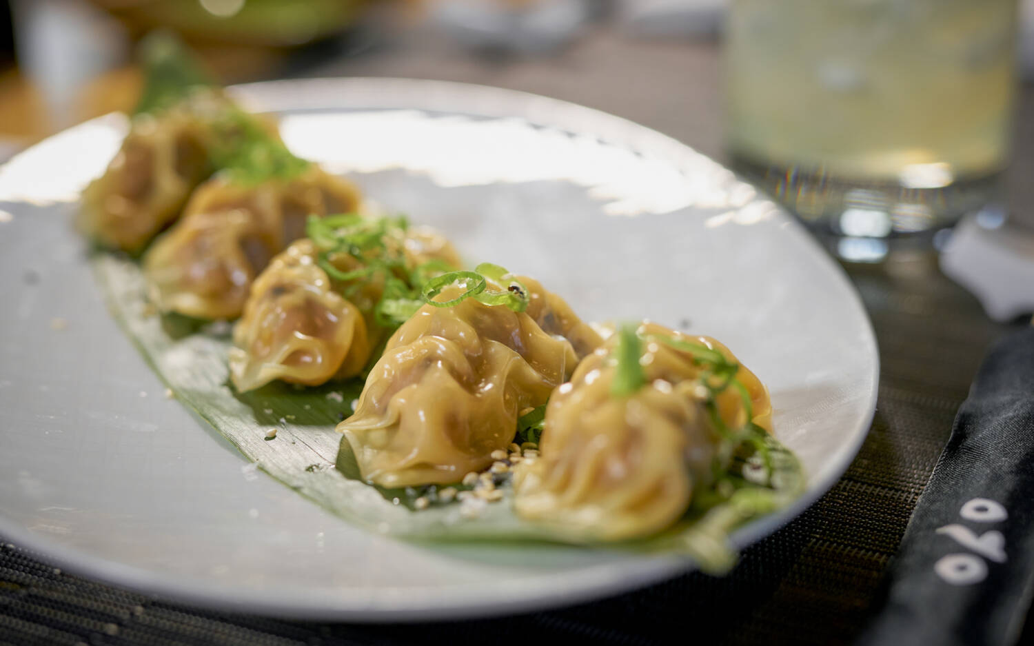 Die gedämpften Dumplings werden auf einem Blatt mit Frühlingszwiebeln serviert / ©Marc SIll 