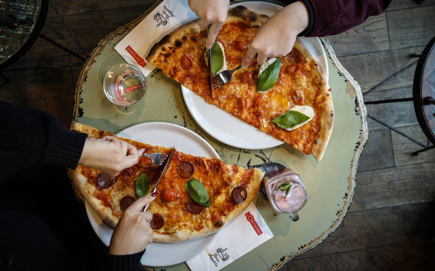 Die L’Osteria ist bekannt für ihre Wagenrad-großen Pizzen, die weit über den Tellerrand hinausragen / ©L’Osteria