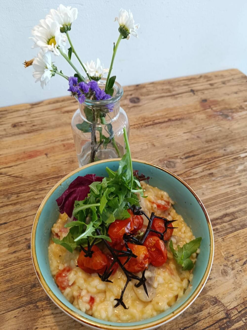 Das Team bereitet täglich einen frischen veganen oder vegetarischen Mittagstisch zu. Hier: ein Pilzrisotto mit konfierten Tomaten / ©Café Rennkoppel