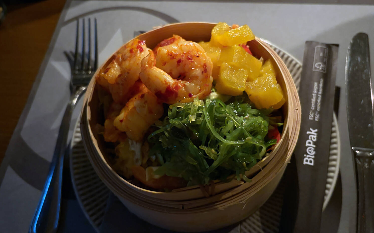 Im BeachHouse auf Sylt werden vier saftige Gambas im Holzkorb serviert, dazu Spicy-Asiasalat, Ananas-Relish, Wakame und Sesamdressing / ©Michael Hein
