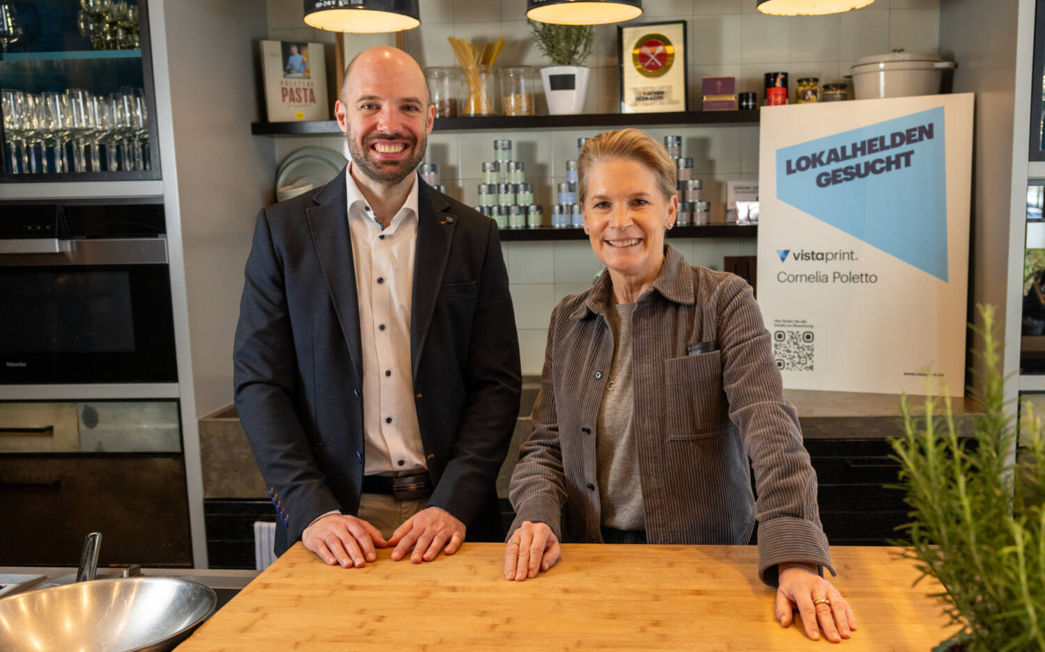 Cornelia Poletto und Daniel Engelhardt von VistaPrint gratulieren der Gewinnerin des Wettbewerbs „Lokalhelden gesucht“ / ©VistaPrint