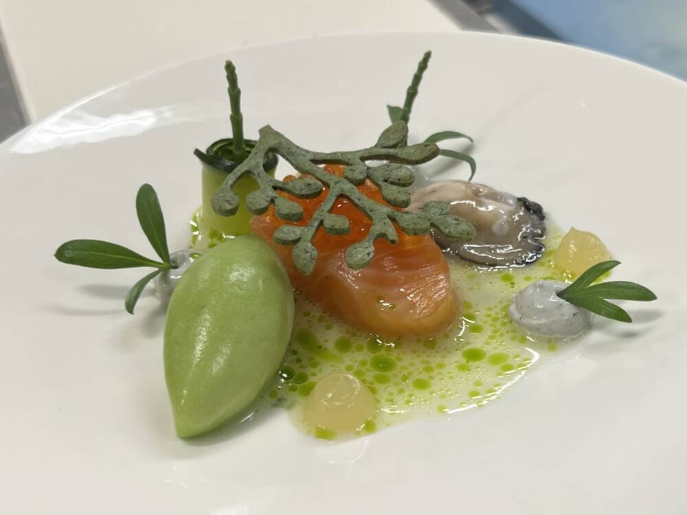 Das Amuse: Dänischer Lachs mit Gewürzgurken-Sorbet, Sylter Auster und Küstenkräutern / ©Paula Rieck