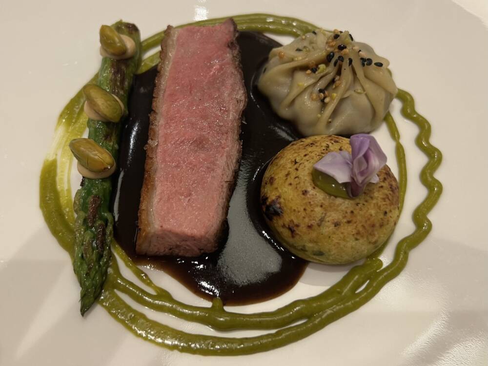 Der Hauptgang des Dinners: Gewürzente mit Szechuan-Pfeffer-Jus, Pistazie und Dim Sum / ©Paula Rieck