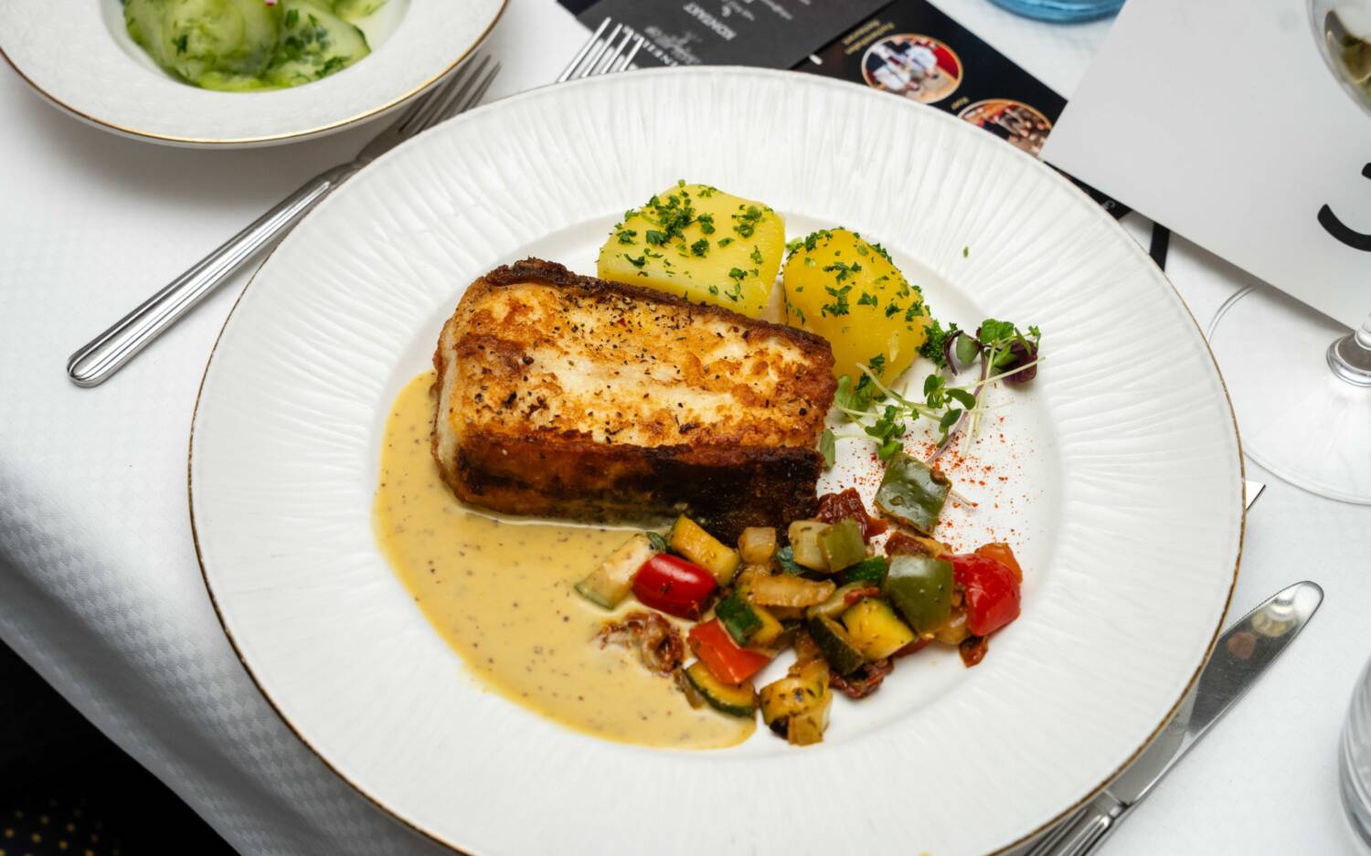 Der Hauptgang vom Fischereihafen Restaurant: weißer Heilbutt mit Pommery-Senfsoße, Petersilienkartoffeln und Gurkensalat / ©SZENE STUDIOS