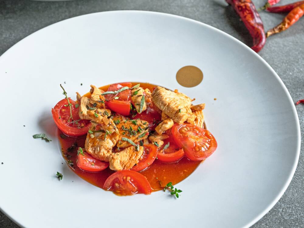 In seinem neuesten Kochbuch widmet sich TV-Koch Rainer Sass schnellen Rezepten. Sein Favorit: scharfes Huhn mit Tomaten / ©Gräfe und Unzer Verlag / Frank von Wieding