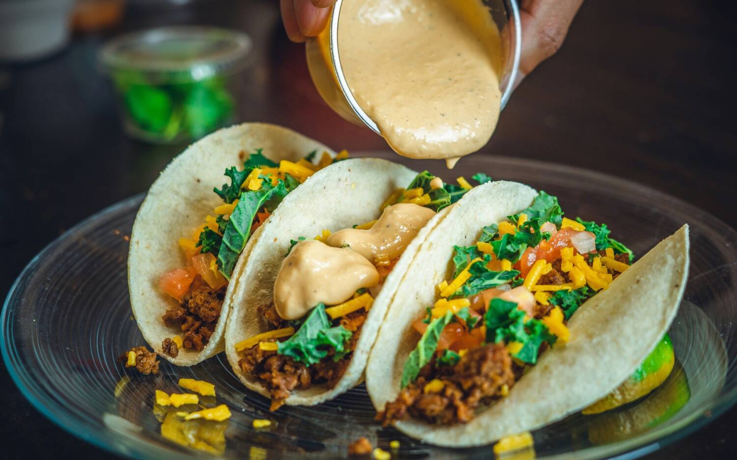 Taco-Trio mit ordentlich Wumms! Würzige Füllung und cremige Soße machen jeden Bissen schön saftig / © Unsplash/Jarett Lopez